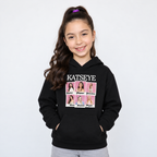 Niña usando polerón KATSEYE negro Pascalle con estampado frontal